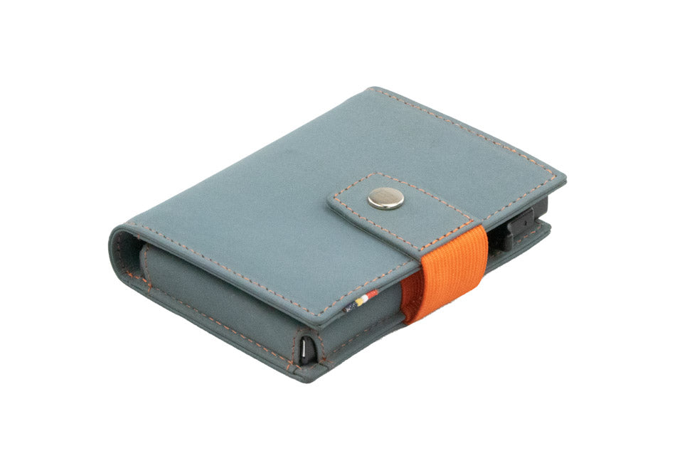 Closed Garzini Metal Wallet in blue leather with snap button and orange strap, viewed from an angle
