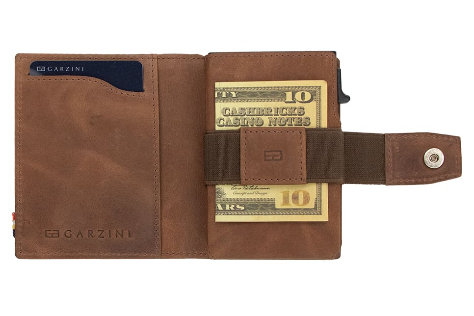 Open Garzini Metal Wallet in brushed brown leather, holding a stack of cash
