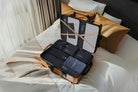 Open suitcase on a bed, organized with Garzini packing cubes