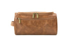 Close-up of Cognac Garzini Toiletry Bag front side, featuring premium vegan leather and brass zipper details.